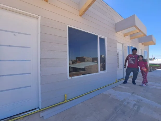 Familia frente a su vivienda recién entregada